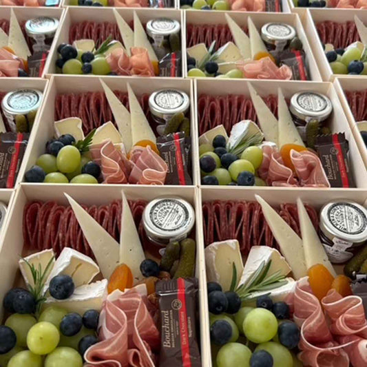 Assorted charcuterie boxes with meats, cheeses, and fruits 