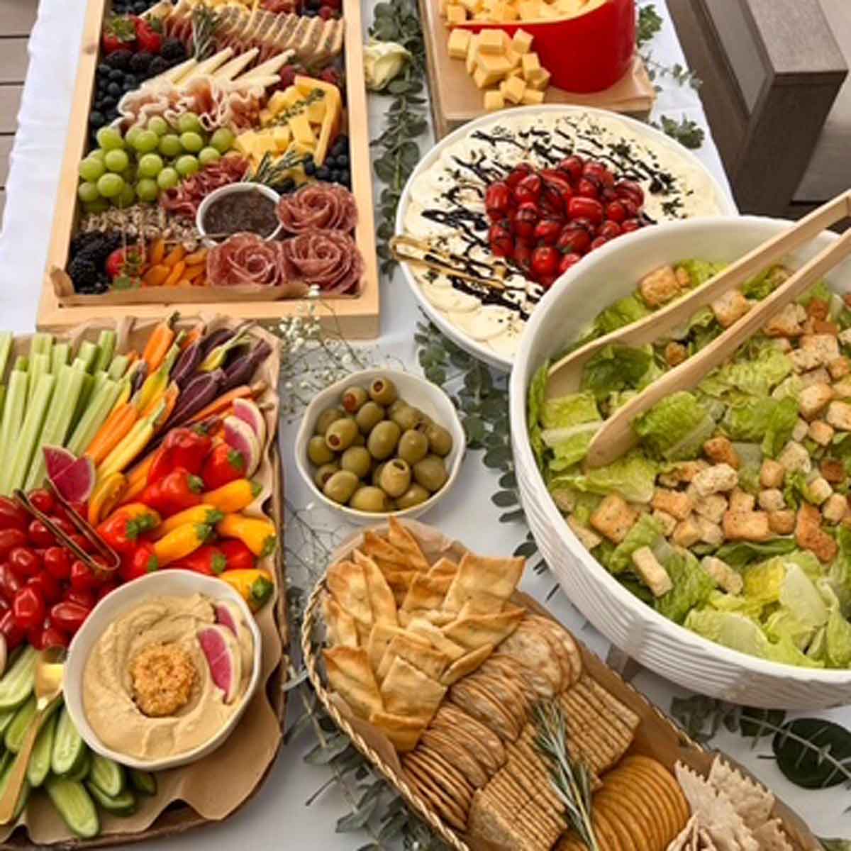 Assorted finger foods including salads, dips, and vegetables on a table.