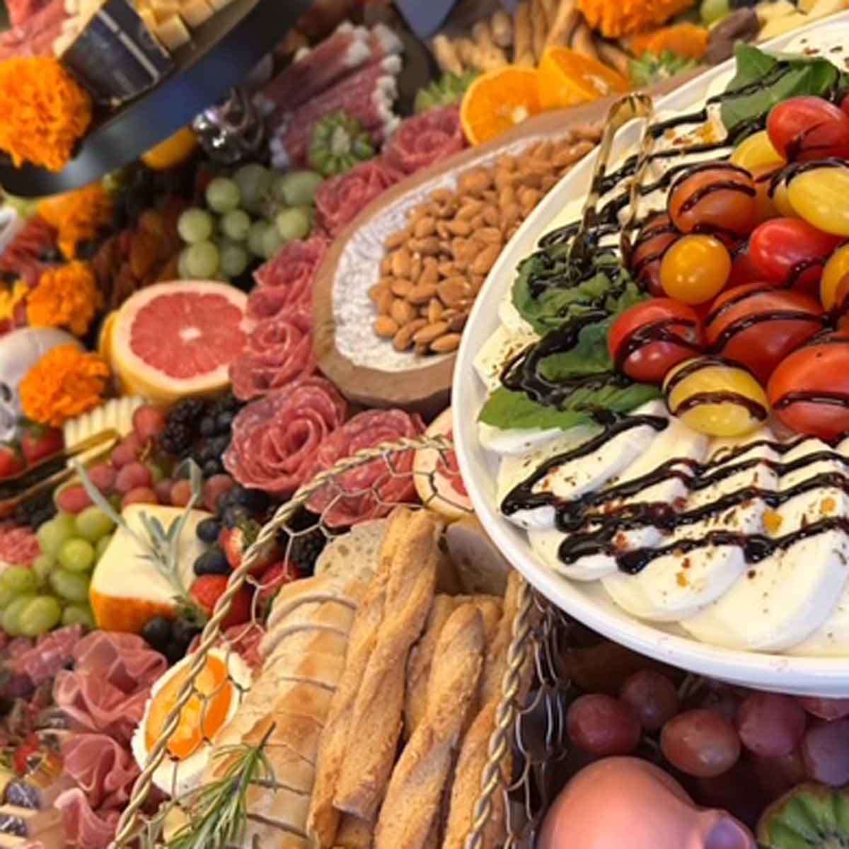 Assorted fruits, cheeses, and breads on a platter with a focus on a bowl of salad.